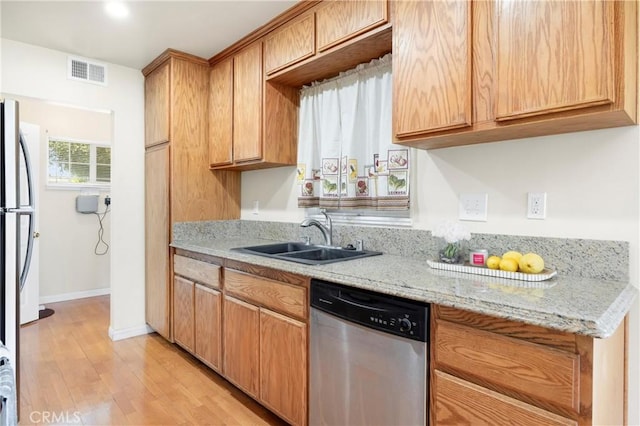 1206 E Vine Ave, West Covina, CA 91790 - kitchen featuring appliances with stainless steel finishes, light wood finished floors, and light stone countertops