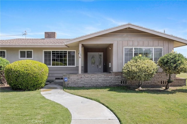 1206 E Vine Ave, West Covina, CA 91790 - ranch-style house featuring a chimney, a front lawn, roof with shingles, and board and batten siding