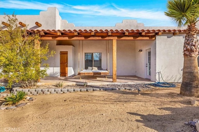 7423 Juniper Rd, Joshua Tree, CA 92252 - back of house featuring stucco siding and a patio area