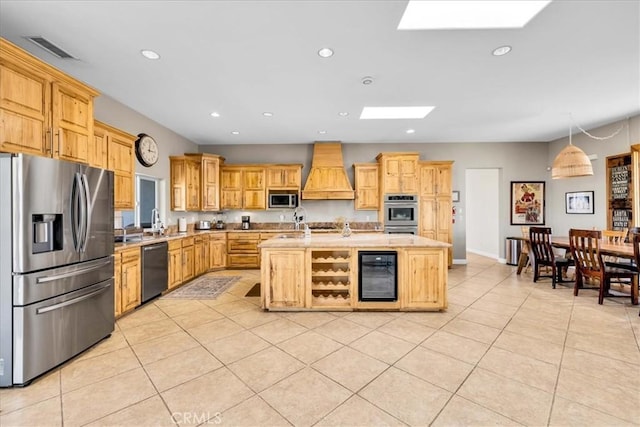 7423 Juniper Rd, Joshua Tree, CA 92252 - kitchen featuring appliances with stainless steel finishes, beverage cooler, a skylight, premium range hood, and recessed lighting