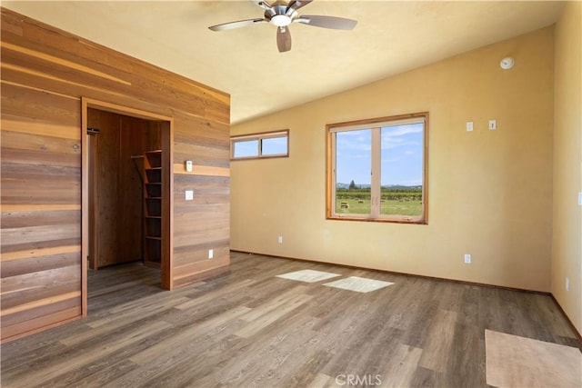 3155 Soda Bay Rd, Lakeport, CA 95453 - unfurnished bedroom with vaulted ceiling, wooden walls, wood finished floors, a closet, and ceiling fan
