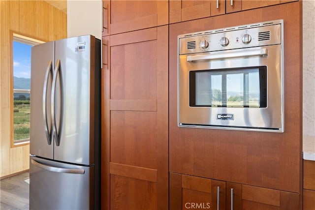 3155 Soda Bay Rd, Lakeport, CA 95453 - kitchen with appliances with stainless steel finishes, brown cabinetry, wood finished floors, and a mountain view