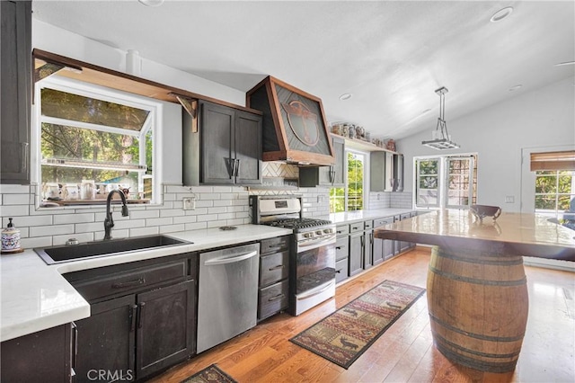 810 Oakmont Ln, Lake Arrowhead, CA 92352 - kitchen with stainless steel appliances, vaulted ceiling, tasteful backsplash, decorative light fixtures, and light wood-type flooring