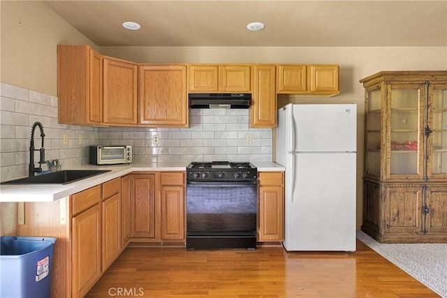 810 Oakmont Ln, Lake Arrowhead, CA 92352 - kitchen featuring freestanding refrigerator, black gas range oven, under cabinet range hood, light countertops, and light wood finished floors