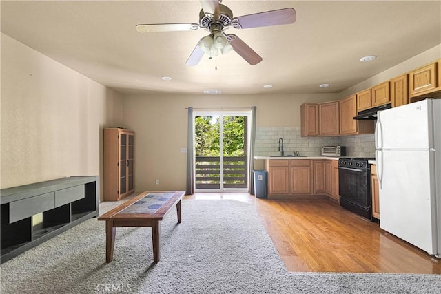 810 Oakmont Ln, Lake Arrowhead, CA 92352 - kitchen with freestanding refrigerator, black gas range oven, under cabinet range hood, light countertops, and light wood-type flooring