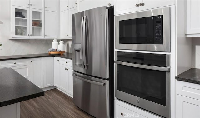 233 Carmelita Ln, Tehachapi, CA 93561 - kitchen with appliances with stainless steel finishes, dark countertops, white cabinetry, glass insert cabinets, and backsplash