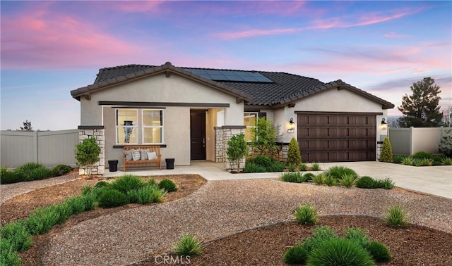 233 Carmelita Ln, Tehachapi, CA 93561 - view of front of home with stucco siding, solar panels, a porch, driveway, and an attached garage