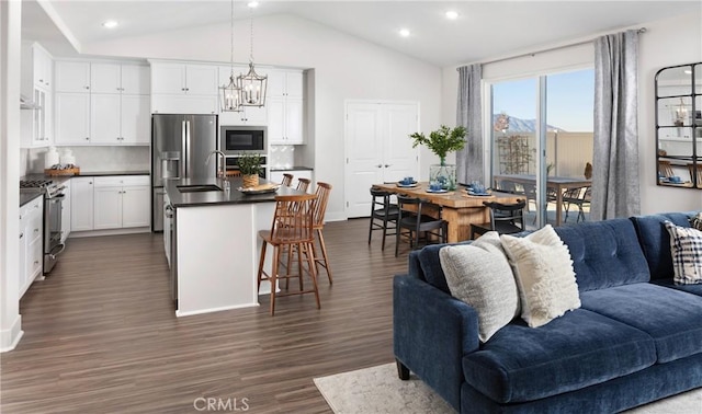233 Carmelita Ln, Tehachapi, CA 93561 - kitchen with open floor plan, appliances with stainless steel finishes, dark countertops, dark wood-style floors, and lofted ceiling