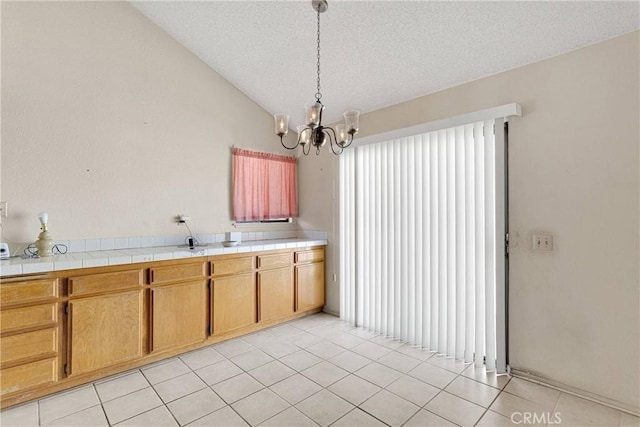 16205 Tokay St, Victorville, CA 92395 - kitchen with a chandelier, light tile patterned floors, a textured ceiling, vaulted ceiling, and hanging light fixtures