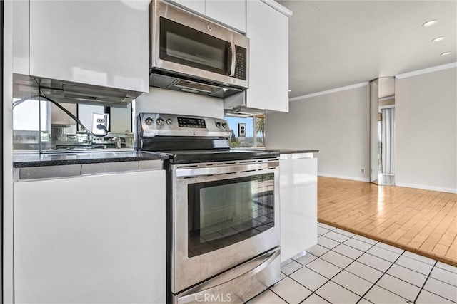 532 N Rossmore Ave Unit 411, Los Angeles, CA 90004 - kitchen with appliances with stainless steel finishes, white cabinetry, crown molding, light tile patterned flooring, and dark countertops