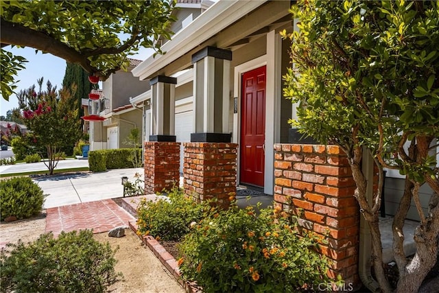 8507 E Heatherview Ln, Orange, CA 92869 - property entrance with brick siding, a porch, and concrete driveway