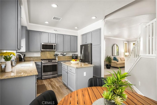 8507 E Heatherview Ln, Orange, CA 92869 - kitchen with appliances with stainless steel finishes, gray cabinetry, crown molding, light stone countertops, and recessed lighting