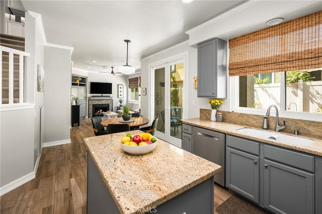 8507 E Heatherview Ln, Orange, CA 92869 - kitchen with gray cabinets, stainless steel dishwasher, a warm lit fireplace, ceiling fan, and recessed lighting