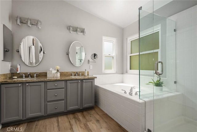 8507 E Heatherview Ln, Orange, CA 92869 - full bath featuring vaulted ceiling, a shower stall, a bath, double vanity, and wood finished floors