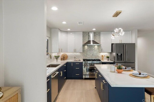 7911 Terraza Disoma, Carlsbad, CA 92009 - kitchen featuring wall chimney range hood, appliances with stainless steel finishes, white cabinetry, pendant lighting, and recessed lighting