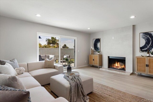 7911 Terraza Disoma, Carlsbad, CA 92009 - living room featuring light wood-type flooring, a brick fireplace, and recessed lighting