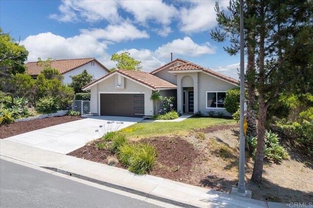 7911 Terraza Disoma, Carlsbad, CA 92009 - mediterranean / spanish-style house with a tile roof, an attached garage, stucco siding, and driveway