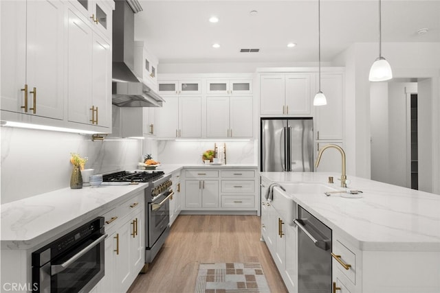 5 Gazania Ct, Chico, CA 95926 - kitchen with stainless steel appliances, wall chimney range hood, light wood-style floors, a kitchen island with sink, and recessed lighting