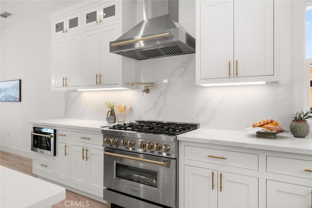 5 Gazania Ct, Chico, CA 95926 - kitchen with wall chimney range hood, high end stove, and white cabinetry