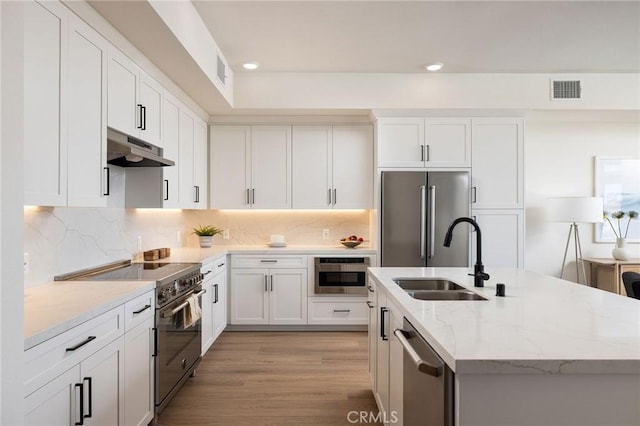414 Main St Unit 430, Huntington Beach, CA 92648 - kitchen with high quality appliances, under cabinet range hood, a kitchen island with sink, light stone countertops, and recessed lighting
