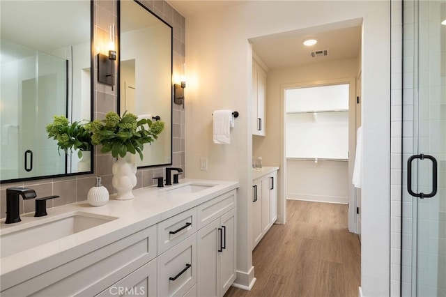 414 Main St Unit 430, Huntington Beach, CA 92648 - full bathroom with a shower stall, double vanity, wood finished floors, and a walk in closet