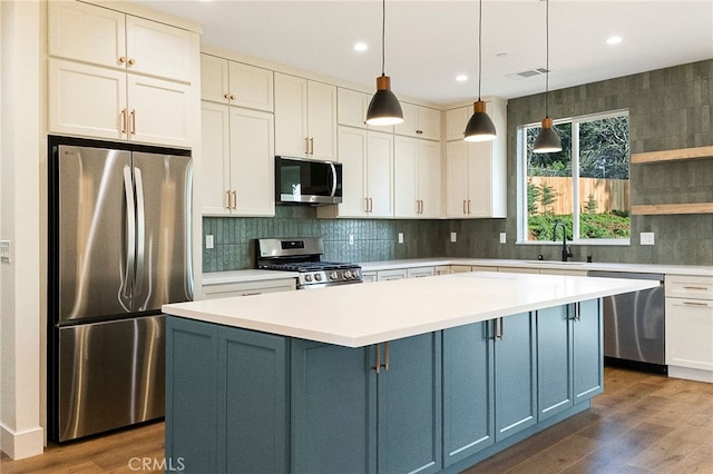 904 Waggoner Rd, Paradise, CA 95969 - kitchen featuring stainless steel appliances, dark wood-style flooring, light countertops, blue cabinetry, and a kitchen island
