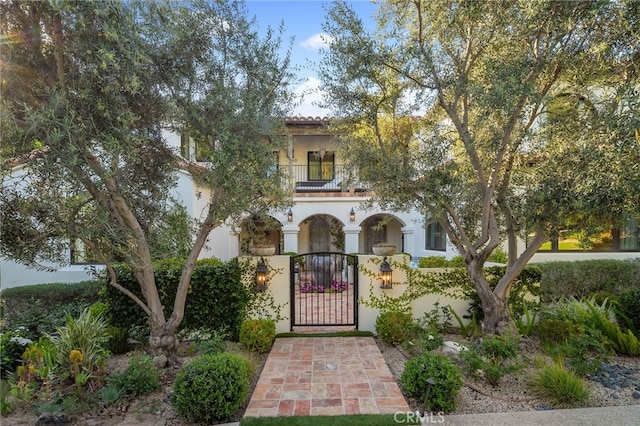 30671 Steeplechase Dr, San Juan Capistrano, CA 92675 - mediterranean / spanish-style house featuring a balcony, a gate, a fenced front yard, and stucco siding