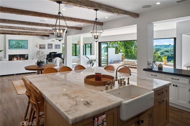 30671 Steeplechase Dr, San Juan Capistrano, CA 92675 - kitchen with open floor plan, dark wood-type flooring, beam ceiling, light stone countertops, and recessed lighting