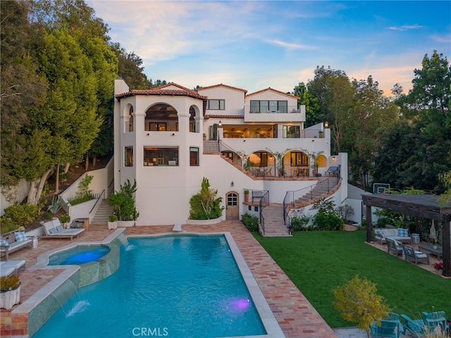 30671 Steeplechase Dr, San Juan Capistrano, CA 92675 - rear view of house featuring stairway, a yard, stucco siding, a patio area, and a pool with connected hot tub
