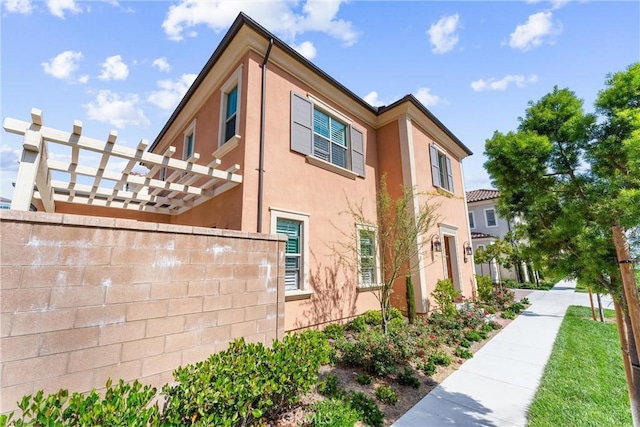 183 Plum Lily, Irvine, CA 92618 - view of side of property with stucco siding and a pergola