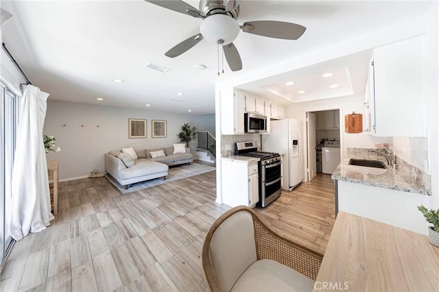 20004 Waverly Glen St Unit 46, Yorba Linda, CA 92886 - kitchen featuring stainless steel appliances, open floor plan, a ceiling fan, white cabinets, and light stone counters