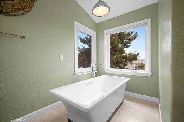 21658 Canyon Heights Cir, Saugus, CA 91390 - bathroom with a soaking tub, plenty of natural light, vaulted ceiling, wood finished floors, and a textured wall