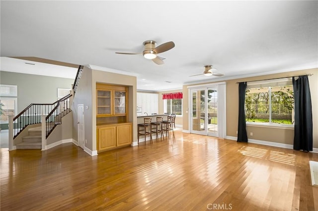 21658 Canyon Heights Cir, Saugus, CA 91390 - unfurnished living room featuring ceiling fan, wood finished floors, stairs, plenty of natural light, and crown molding
