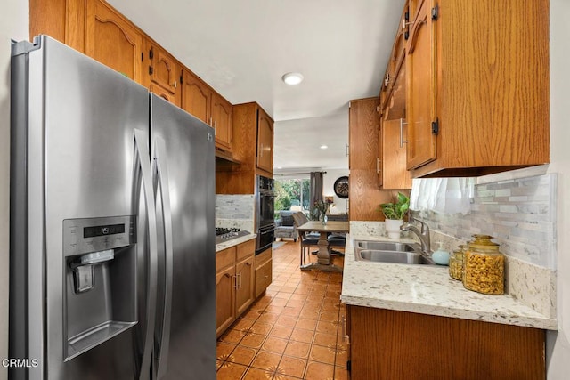 215 Bridewell St, Los Angeles, CA 90042 - kitchen with stainless steel fridge with ice dispenser, tasteful backsplash, light countertops, light tile patterned floors, and brown cabinetry