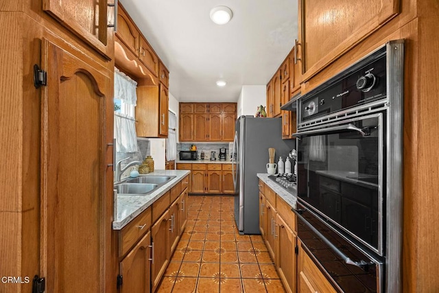 215 Bridewell St, Los Angeles, CA 90042 - kitchen featuring black appliances, a warming drawer, brown cabinetry, light countertops, and light tile patterned floors