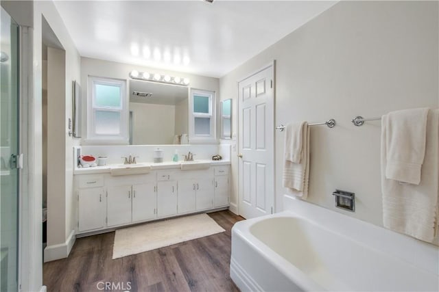 1212 Dover Dr, Newport Beach, CA 92660 - bathroom featuring double vanity, wood finished floors, a garden tub, and a stall shower