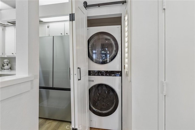 17202 Corbina Ln Unit 103, Huntington Beach, CA 92649 - laundry area featuring stacked washer / dryer and light wood-style flooring