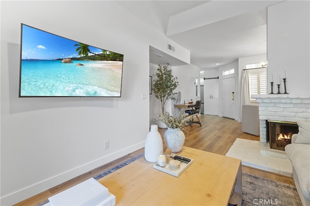 17202 Corbina Ln Unit 103, Huntington Beach, CA 92649 - living room featuring a barn door, wood finished floors, and a fireplace