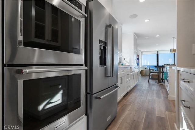 335 W I St, Encinitas, CA 92024 - kitchen with appliances with stainless steel finishes, white cabinetry, wood finished floors, light countertops, and recessed lighting