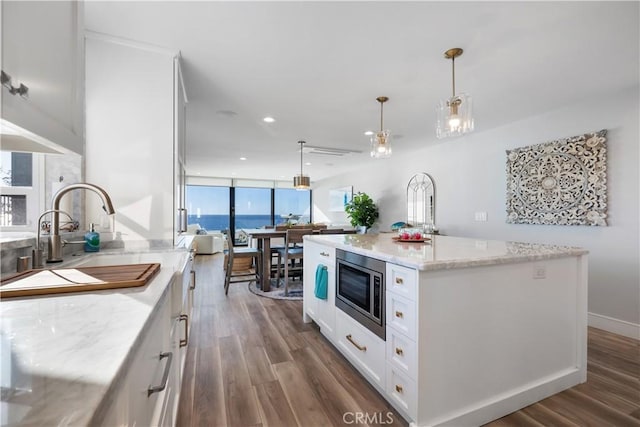 335 W I St, Encinitas, CA 92024 - kitchen featuring stainless steel microwave, dark wood-style floors, white cabinetry, light stone countertops, and recessed lighting