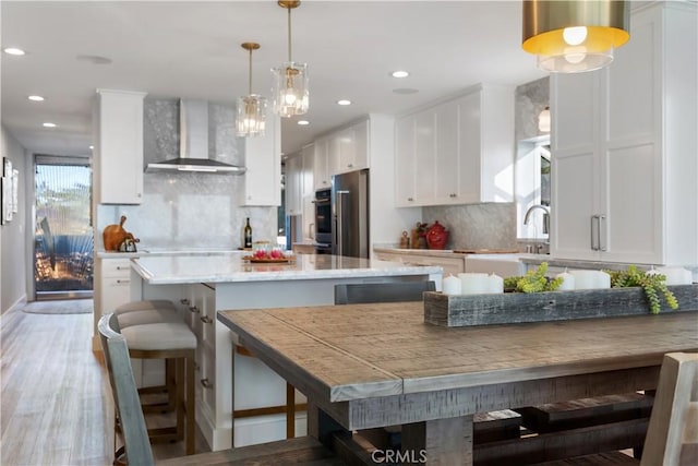 335 W I St, Encinitas, CA 92024 - kitchen featuring wall chimney exhaust hood, appliances with stainless steel finishes, white cabinets, tasteful backsplash, and recessed lighting