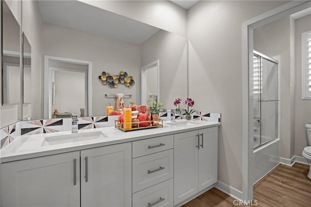 13902 Hidden Pines Ct, Victorville, CA 92392 - bathroom featuring double vanity, wood finished floors, and bath / shower combo with glass door