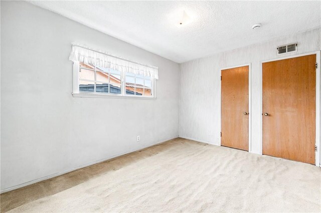6116 Choctaw Dr, Westminster, CA 92683 - unfurnished bedroom featuring carpet, two closets, and a textured ceiling