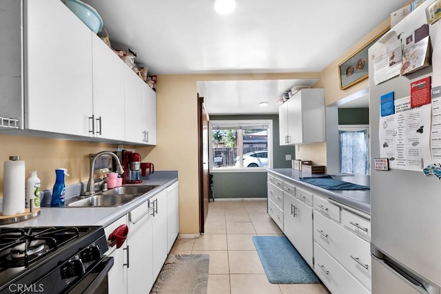 19147 Ingomar St, Reseda, CA 91335 - kitchen with freestanding refrigerator, light tile patterned flooring, white cabinets, light countertops, and black gas stove