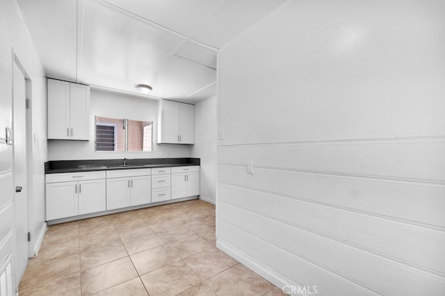 19147 Ingomar St, Reseda, CA 91335 - kitchen with dark countertops, white cabinets, and light tile patterned flooring