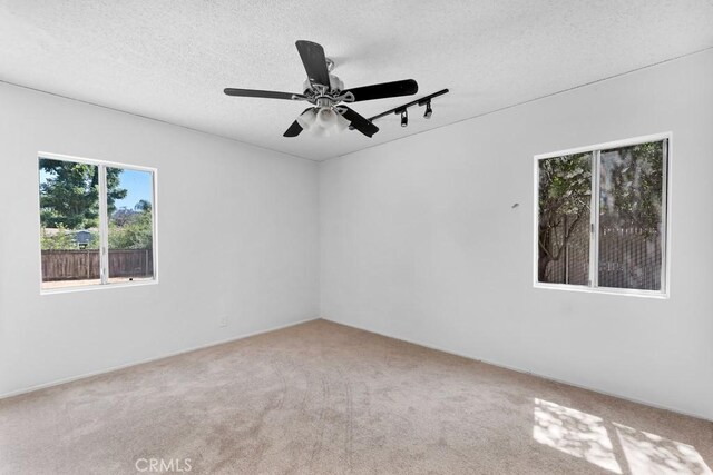 19147 Ingomar St, Reseda, CA 91335 - carpeted empty room featuring a textured ceiling, rail lighting, and a ceiling fan