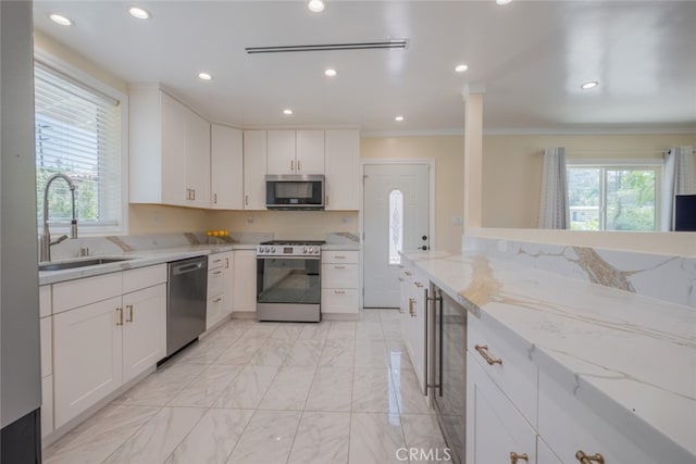 1741 Wabasso Way, Glendale, CA 91208 - kitchen featuring appliances with stainless steel finishes, light marble finish floors, light stone countertops, white cabinets, and crown molding