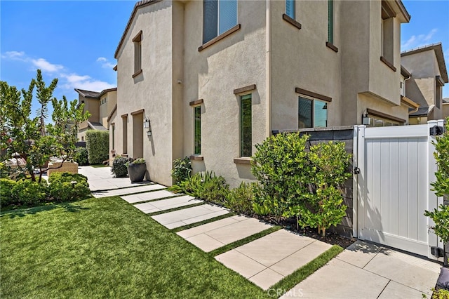 3372 Ivy Way, Rancho Mission Viejo, CA 92694 - view of side of home featuring a gate, stucco siding, and a residential view