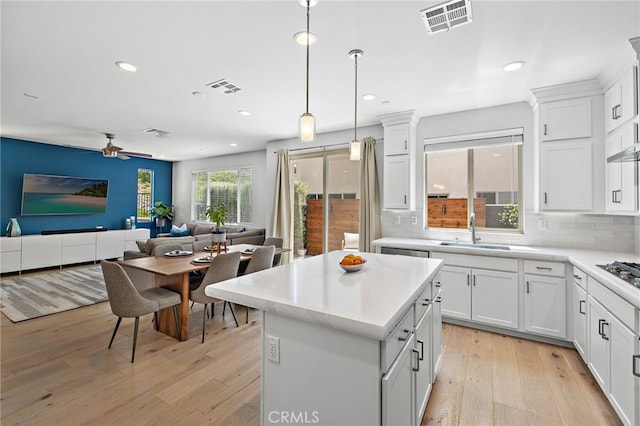 3372 Ivy Way, Rancho Mission Viejo, CA 92694 - kitchen with open floor plan, light wood-type flooring, a kitchen island, light countertops, and decorative light fixtures