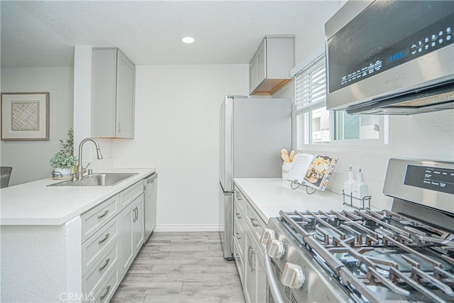 15300 Ocaso Ave Unit E102, La Mirada, CA 90638 - kitchen featuring appliances with stainless steel finishes, light countertops, light wood finished floors, recessed lighting, and a peninsula